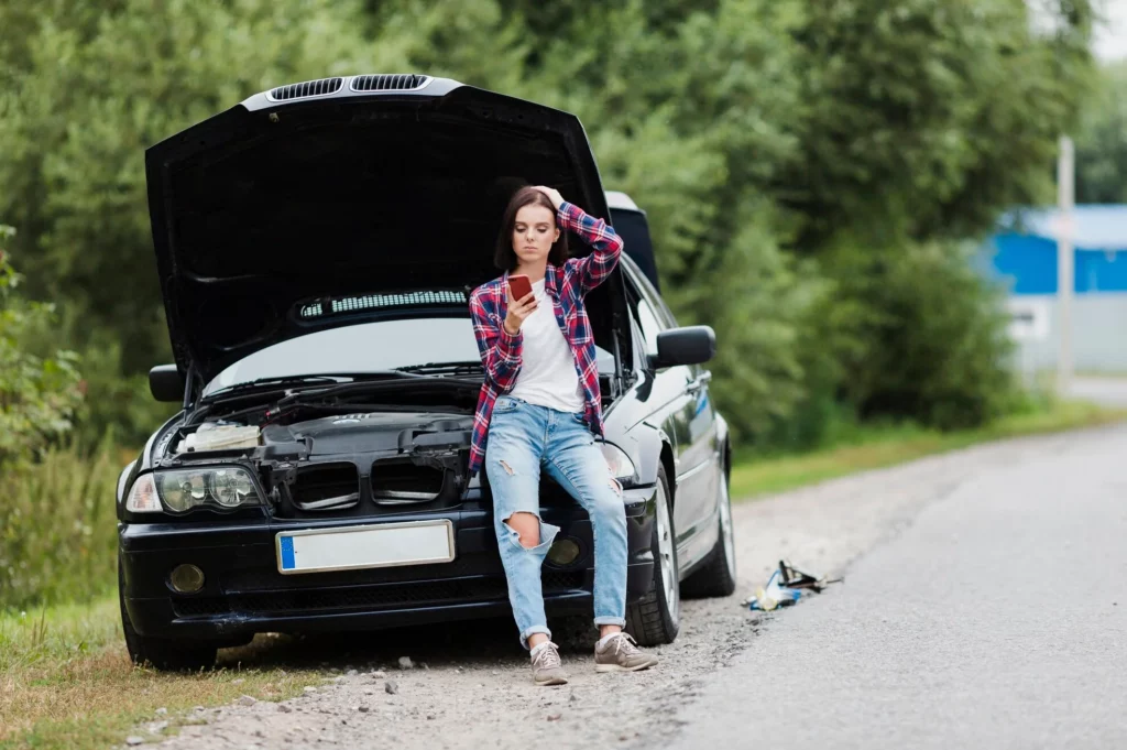 long shot of woman sitting on car